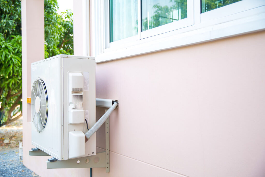 A air conditioner installed outside a house, providing cooling for the home during warm weather.