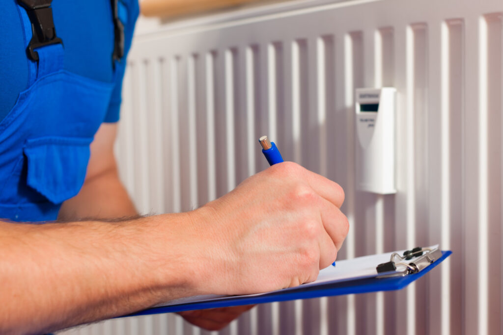 A man is working on a HVAC unit, emphasizing his role in heating system maintenance.